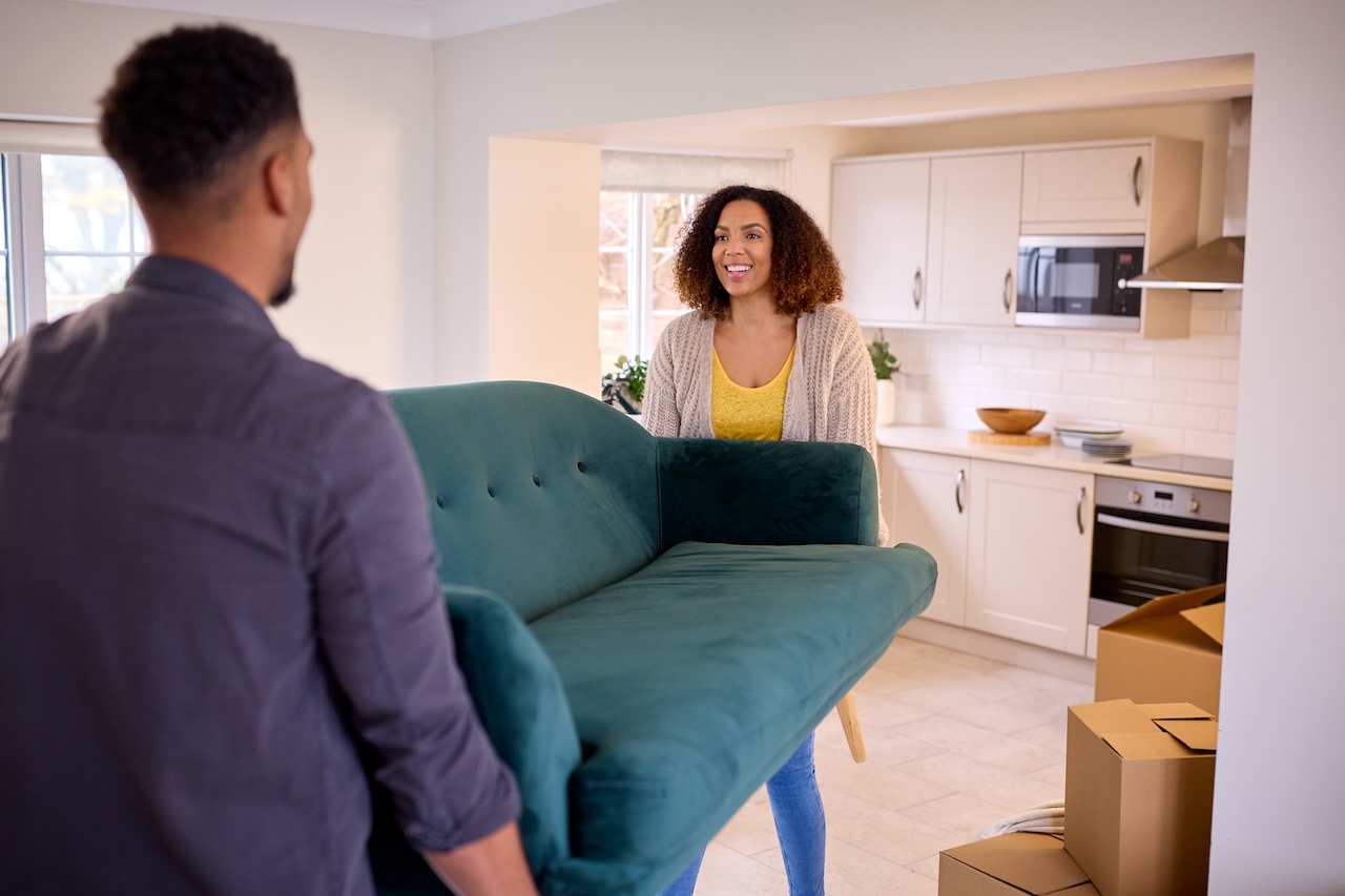 couple moving heavy furniture to put into furniture storage